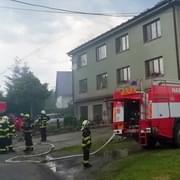 Dědečka s vnoučkem museli hasiči z hořící bytovky na zem snést pomocí výškové techniky