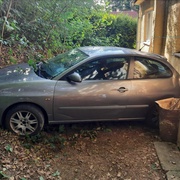 Špatně zabrzděné auto sjelo ze srázu, prorvalo si cestu křovinami a nabouralo do budovy