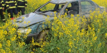 Žena s autem metala kozelce v řepce