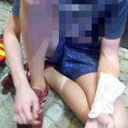 Muž se usadil na chodníku a začal se řezat na předloktí