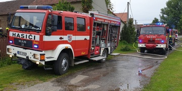 Hasiči bojují s požárem hospodářského stavení