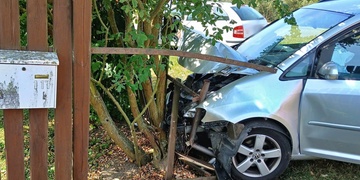 Po střetu dvou aut skončilo jedno z nich v plotu domu