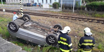 Auto skončilo převrácené v kolejích