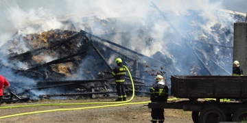 Požár v zemědělské areálu, jeden z hasičů skončil v nemocnici